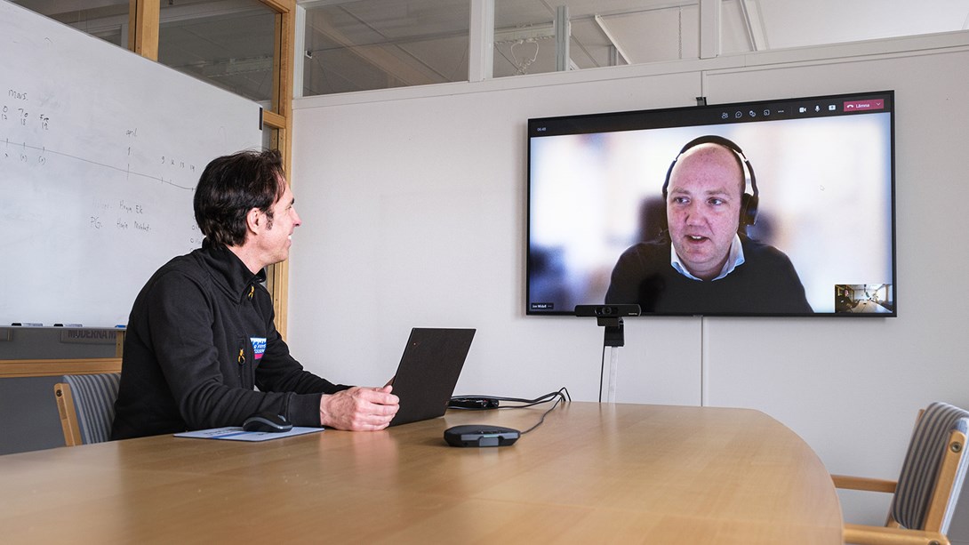 En man har ett videomöte i ett konferensrum