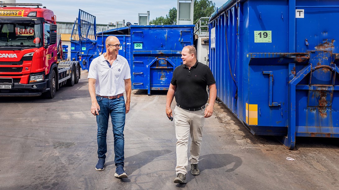 Två män gående på en återvinningscentral