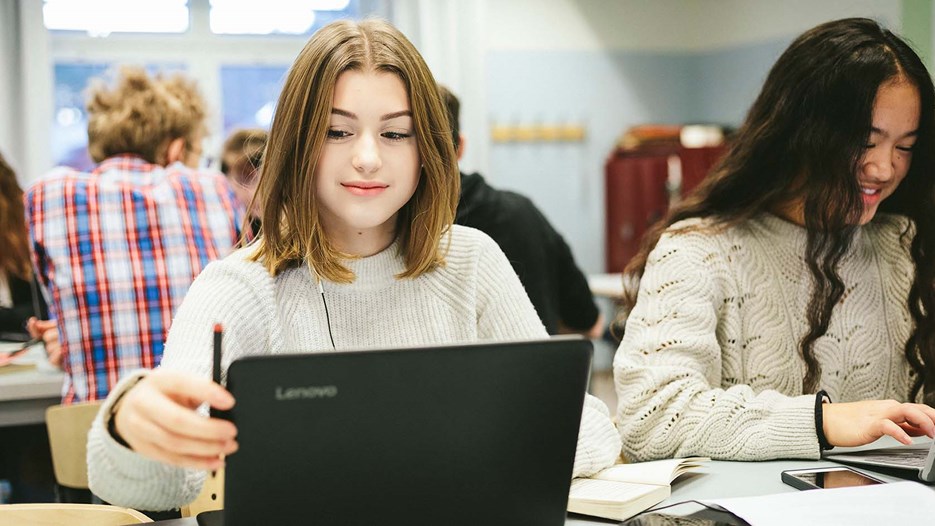 två elever arbetar vid datorer i klassrum