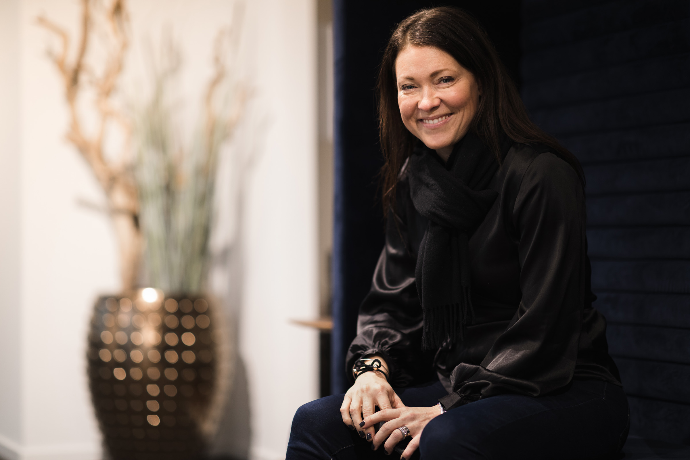 Kvinna sitter och poserar leende