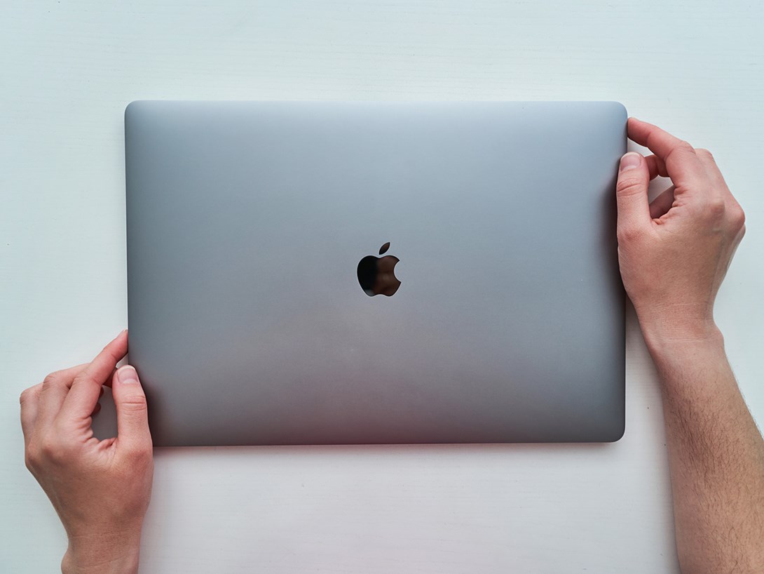 Händer håller en Apple Macbook